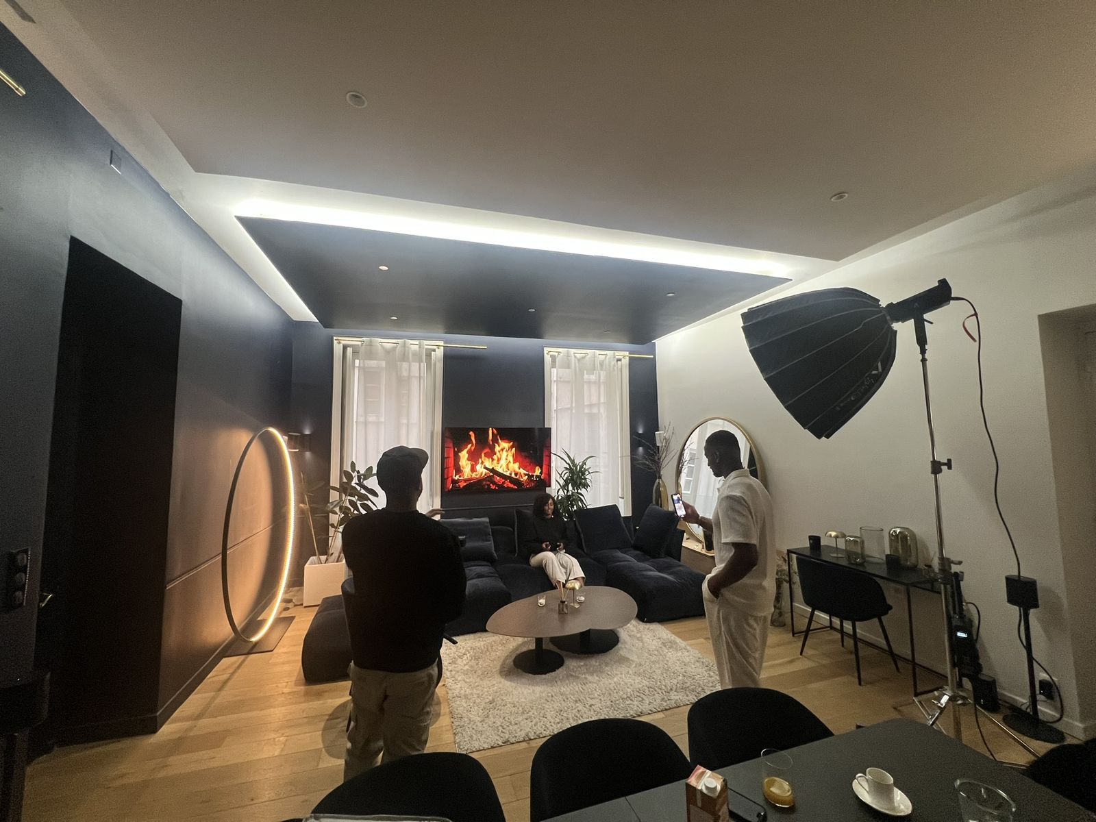 Tournage de clip dans le salon de la WinHome : feu de cheminée sur l'écran géant, projecteur et équipe technique